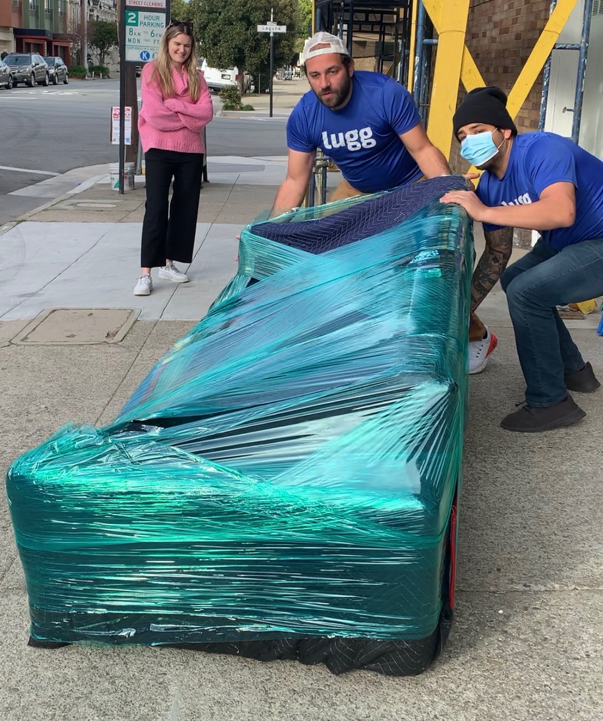 Claire McCann, public school educator on a mission to make $25,000 profit flipping furniture in one year has already made $22,500. She's standing outside her storage unit in the Bay Area, San Franciso, with 2 Lugg Movers who are wrapping a Joy Bird Couch before it heads off for delivery to it's new home.