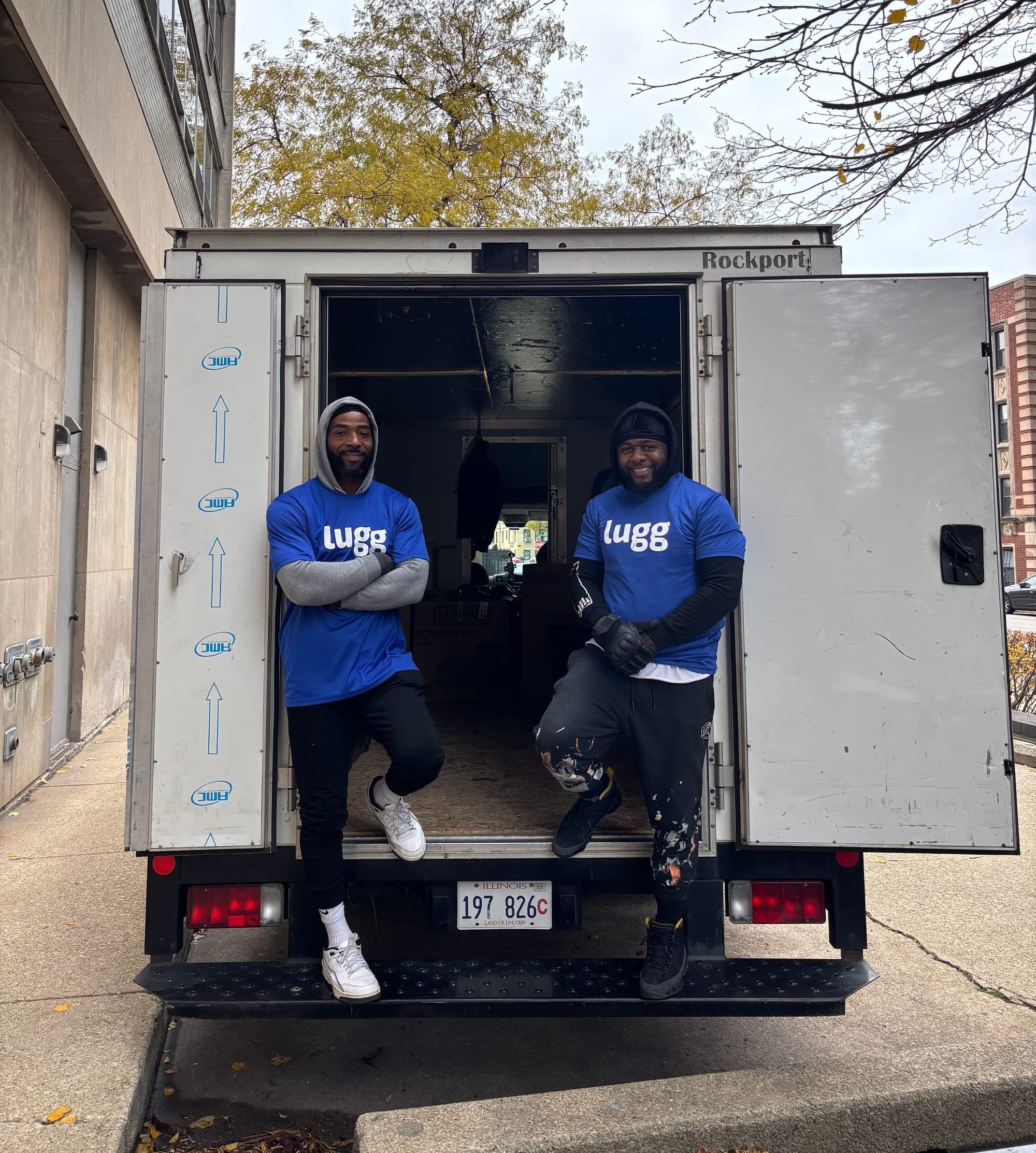 Two Lugg movers standing inside an open box truck during a city move, representing the professional 2-person crew included with Lugg Box.