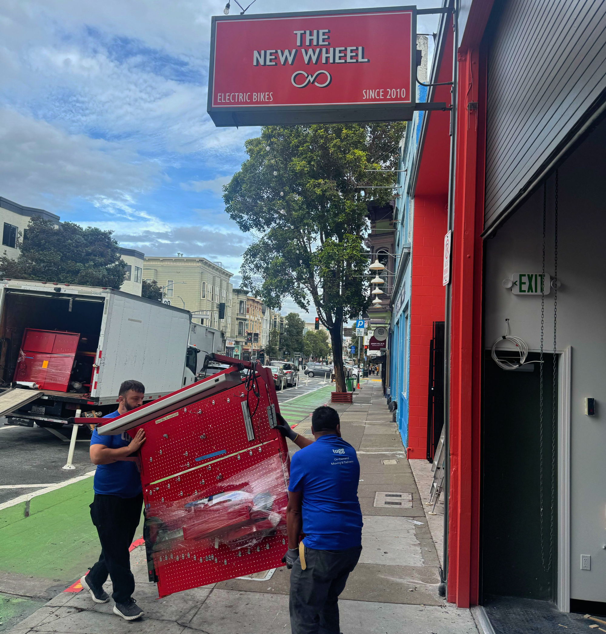 Two Lugg movers carrying a heavy workbench into The New Wheel's new service center at 1031 Valencia Street, San Francisco