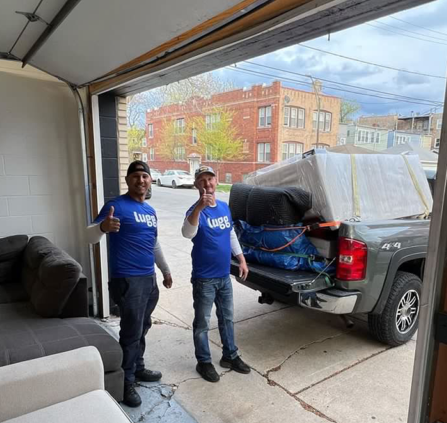Lugg movers in front of a sofa loaded into a pickup truck for a furniture return